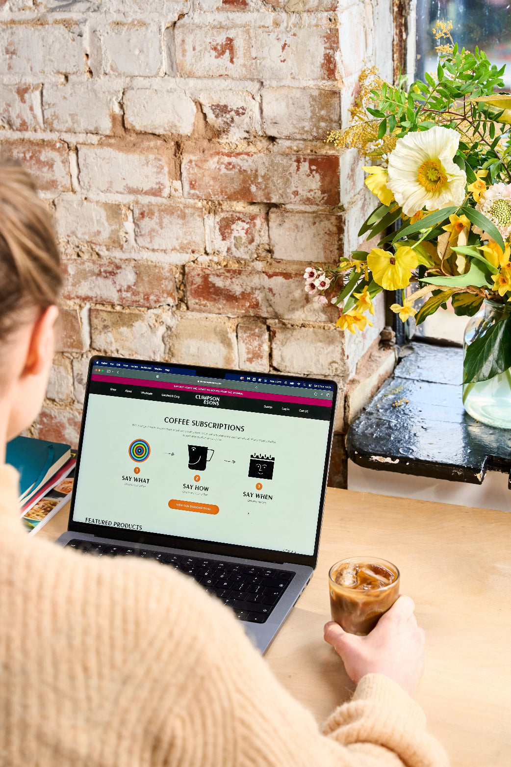 Person on laptop with iced coffee