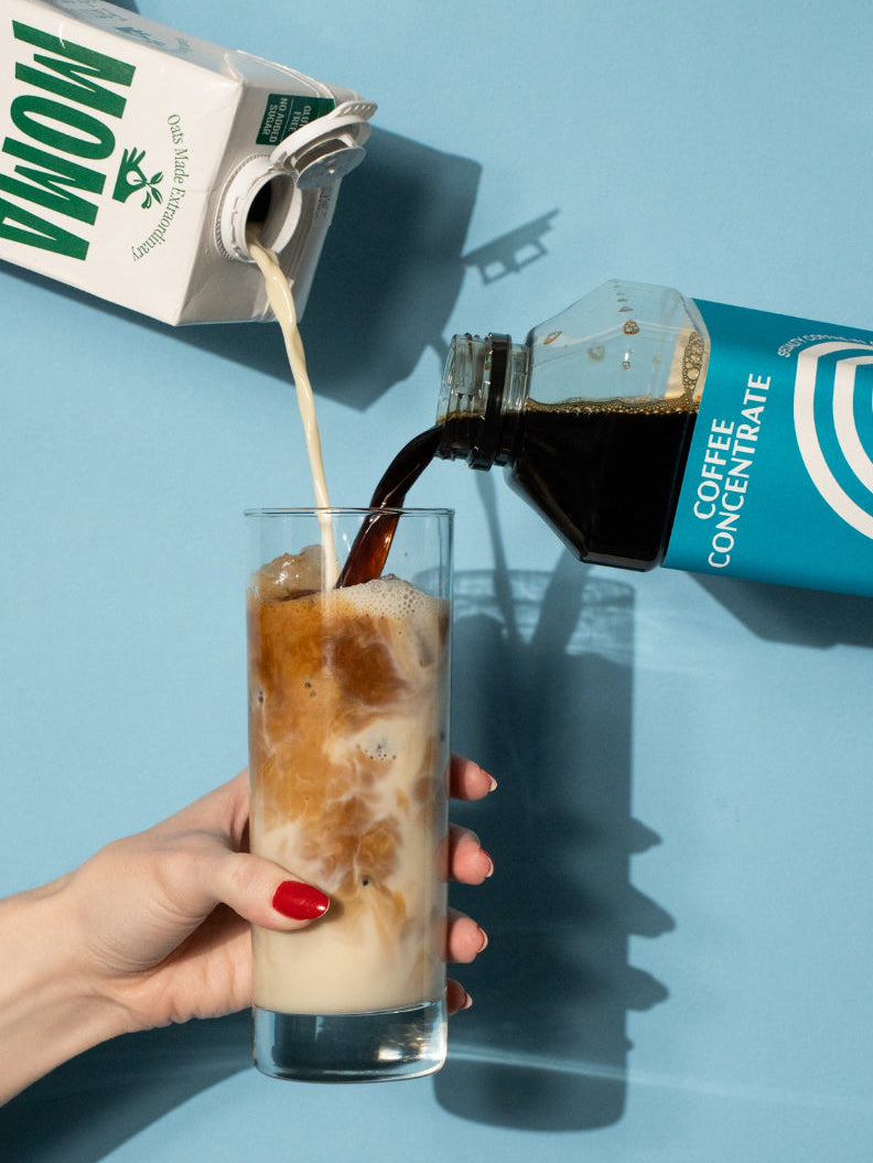 Oat milk and coffee concentrate poured into glass